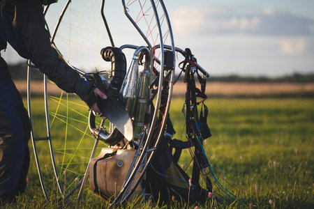 A male pilot is preparing a gasoline-powered paralet for flights. Paragliding for individual paragliding flights. Preparation for wing flight. Extreme sports.の写真素材