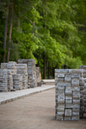 Pavement repair and laying of paving slabs on the walkway, stacked tile cubes on the background....