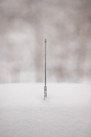 The car antenna is covered with ice and a thick layer of snow. Aerial on the roof of a car on a cold snowy day.の写真素材