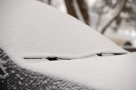 The first unexpected snowfall covered cars with snow. Rearview mirror in the snow. Traffic safety. Selective focusの写真素材