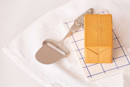 Cheese knife and brown scandinavian cheese on a cutting board. Scandinavian traditions and healthy food.の写真素材