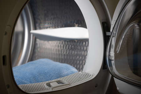 Folded clean blue towels in the drum of the washing machine. Clean concept. Laundry. A close-up of...