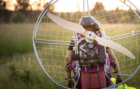 A male pilot is preparing a gasoline-powered paralet for flights. Paragliding for individual paragliding flights. Preparation for wing flight. Extreme sports.の写真素材