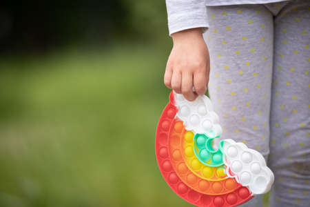 New popular silicone a rainbow colorful antistress toy pop it in the hands of a child. simple dimple. closeup. selective focusの写真素材