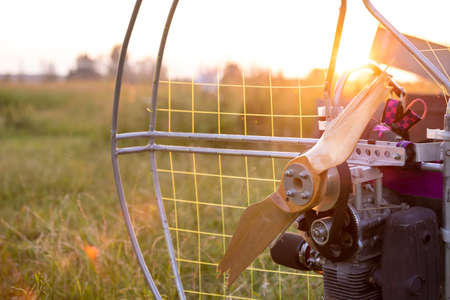 Broken wooden propeller of a gasoline-powered paraglider after a failed landing in the evening sun...