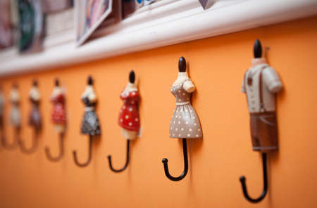 Close up wall hanger. A funny hanger in the form of human figures in different clothes. Vintage...