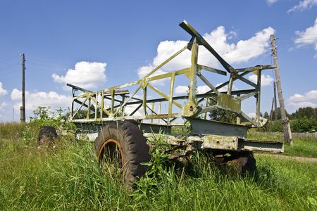 old cart on background of meadow and blue skyの写真素材