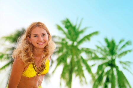 Smiling girl on palm tree backgroundの写真素材