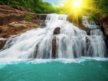 Waterfall pool in rain forest and sunlight