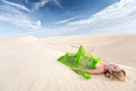 Beautiful woman sleeping in the middle of desertの写真素材