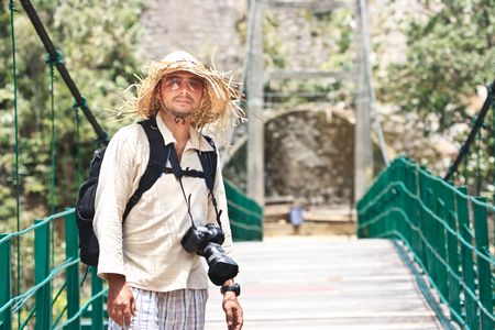 Tourist with camera and backpack on the bridgeの写真素材