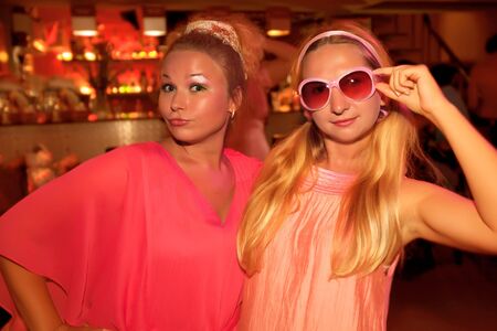 Two young beautiful women at pink partyの写真素材