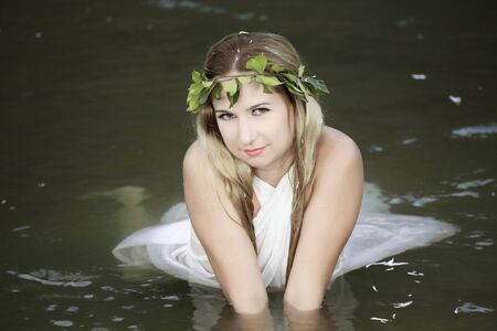 Beautiful woman as a forest nymph on the riverの写真素材