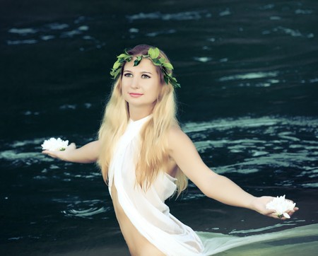 Beautiful woman as a forest nymph on the riverの写真素材