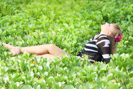 Beautiful woman in grass with gerbera flowersの写真素材