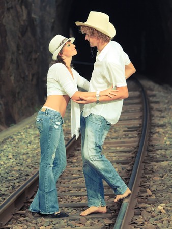 Young couple posing on a train tracksの写真素材