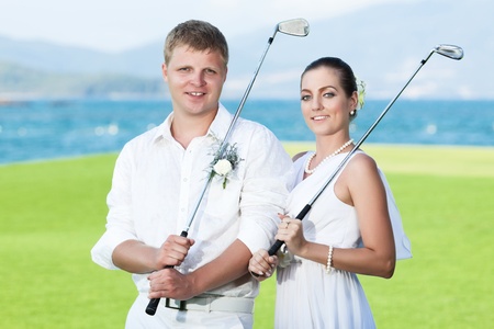Bride and groom are playing golf at wedding dayの写真素材