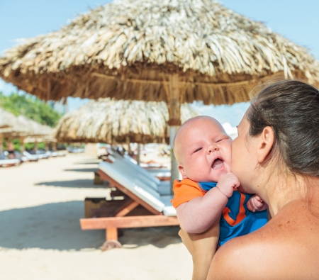Baby and mom are relaxing on sunbedの写真素材