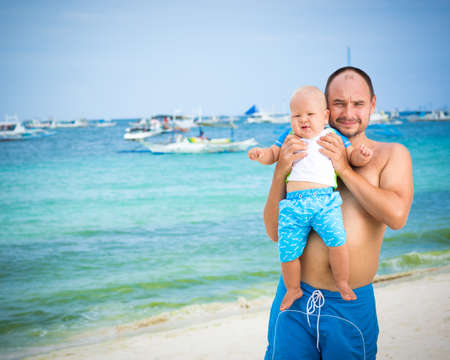 Baby and father on the tropical beachの写真素材