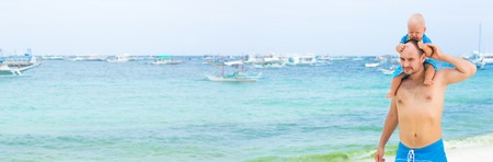 Baby and father on the tropical beachの写真素材
