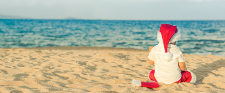 Little Santa on the beach. Panoramaの写真素材