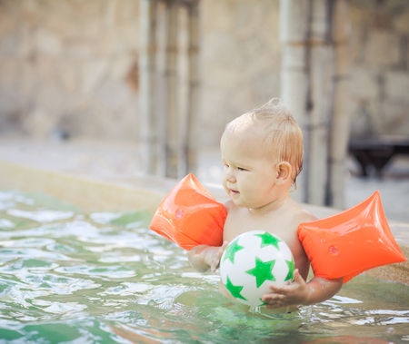 Baby with armbands in swimming poolの写真素材