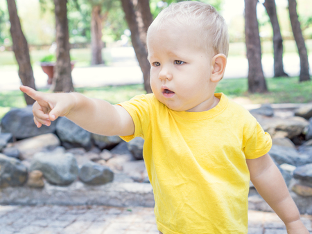 Outdoor portrait of the cute baby pointingの写真素材