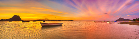 Fishing boat at sunset time. Le Morn Brabant on background. Mauritius. Panoramaの写真素材