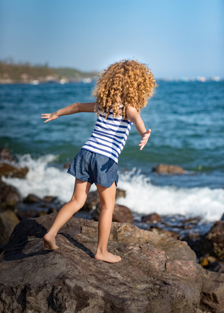 Little girl near the sea playingの写真素材
