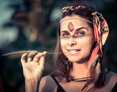 Portrait of a beautiful ethnic woman posing outdoor. Creative makeupの写真素材