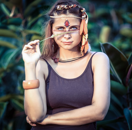 Portrait of a beautiful ethnic woman posing outdoor. Creative makeupの写真素材