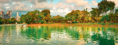 Panoramic view of Bangkok skyline, Thailand. View from Lumphini park. Pond on the foreground