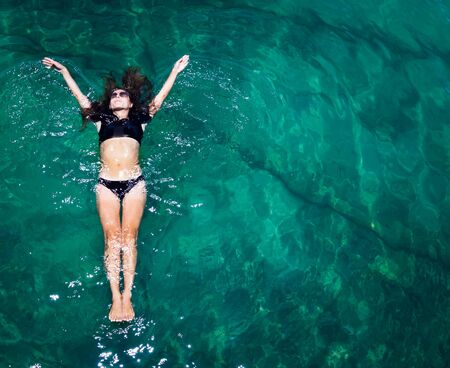 Aerial view of a woman relaxing in the sea の写真素材