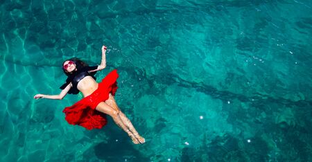 Aerial view of a beautiful woman dancing  in the seaの写真素材