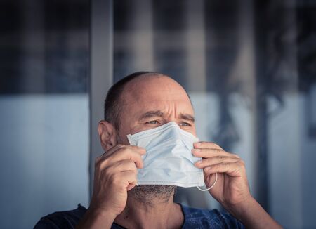 Man wearing facial disposable mask to avoid viral infection. Virus protectionの写真素材
