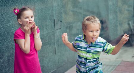 Boy and girl doing funny faces outdoorの写真素材