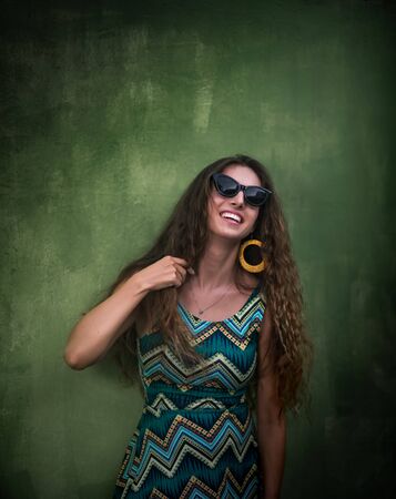 Outdoor portrait of a beautiful woman next green wallの写真素材