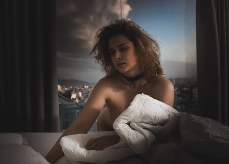 Fashion style low key portrait of a beautiful  woman next to windowの写真素材