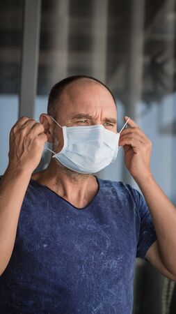 Man wearing facial disposable mask to avoid viral infection. Virus protectionの写真素材