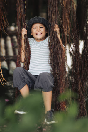 Boy having fun on the lake with banyan treeの写真素材