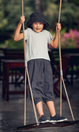 Boy having fun in the park on a swingの写真素材