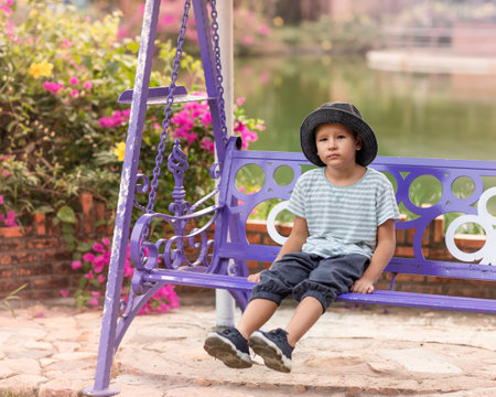 Boy having fun in the park on a swingの写真素材