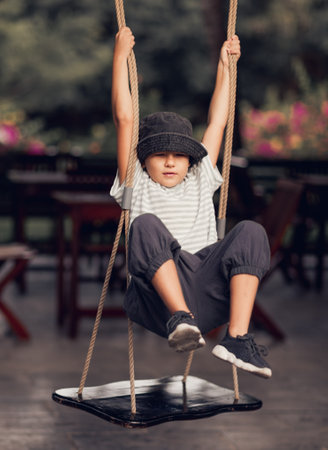 Boy having fun in the park on a swingの写真素材