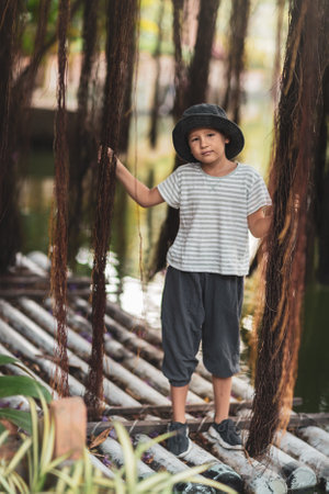 Boy having fun on the lake with banyan treeの写真素材