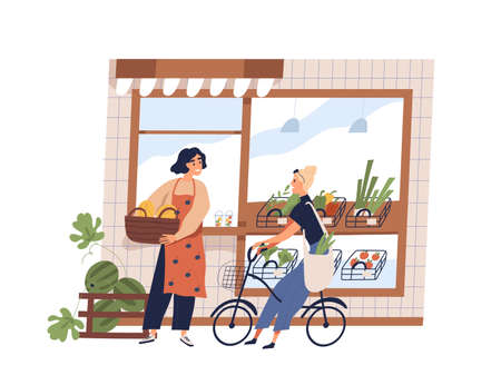 Friendly woman greengrocer and buyer at grocery facade vector flat illustration. Smiling female owner working at small shop with vegetables and fruits isolated. Girl customer on bike talk with sellerのイラスト素材