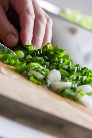 woman cutting onion on the wooden boardの写真素材