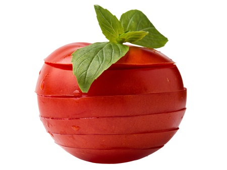 sliced red tomato with basil leaves on top isolated on white backgroundの写真素材
