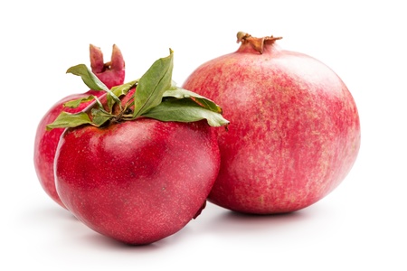 three pomegranates with leaves isolated on whiteの写真素材