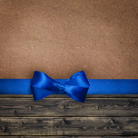 elegant background with blue bow over paper and woodの写真素材