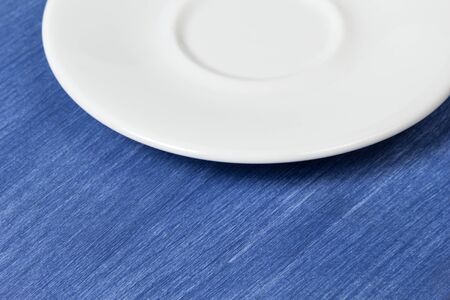 empty saucer on blue wooden surface, can be used as a background